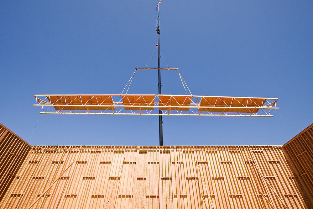 long span open web trusses being modularly installed via crane