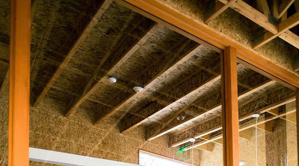 Looking through a glass door at a I-joists installed