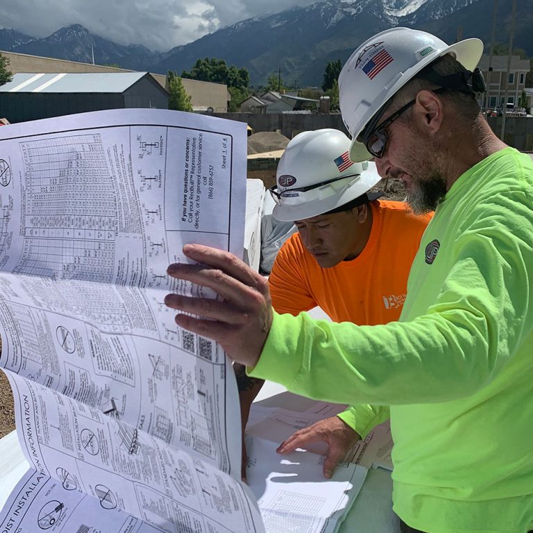 two people working on a jobsite looking at plans