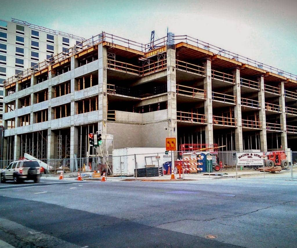 A large structure undergoing concrete forming on the corner of an intersection