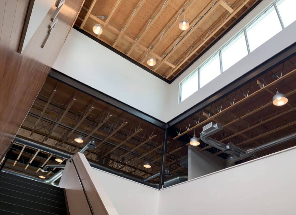 A stairway leads up to a floor with exposed wood products