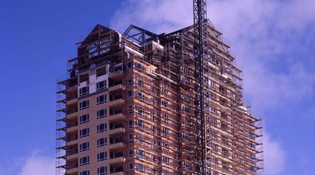 scaffold planks surround a large building in the middle of construction