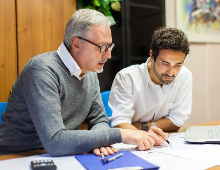 Two employees speak together at a table