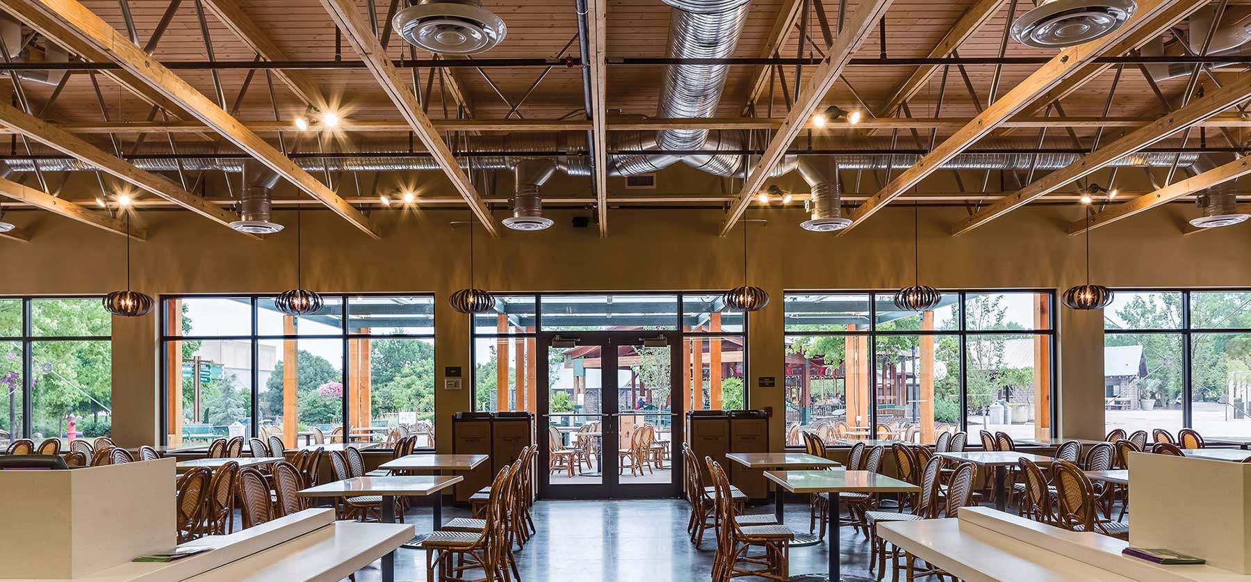 Open Web Trusses exposed in a cafeteria, showcasing durable wood and metal framework, stability, tension, compression, and efficient installation.
