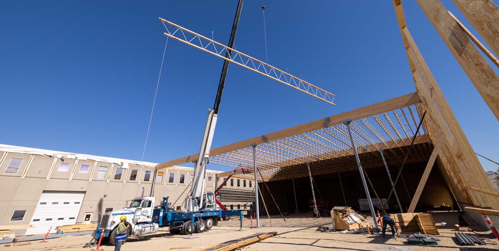 Outside building view of crane flying in an open web truss