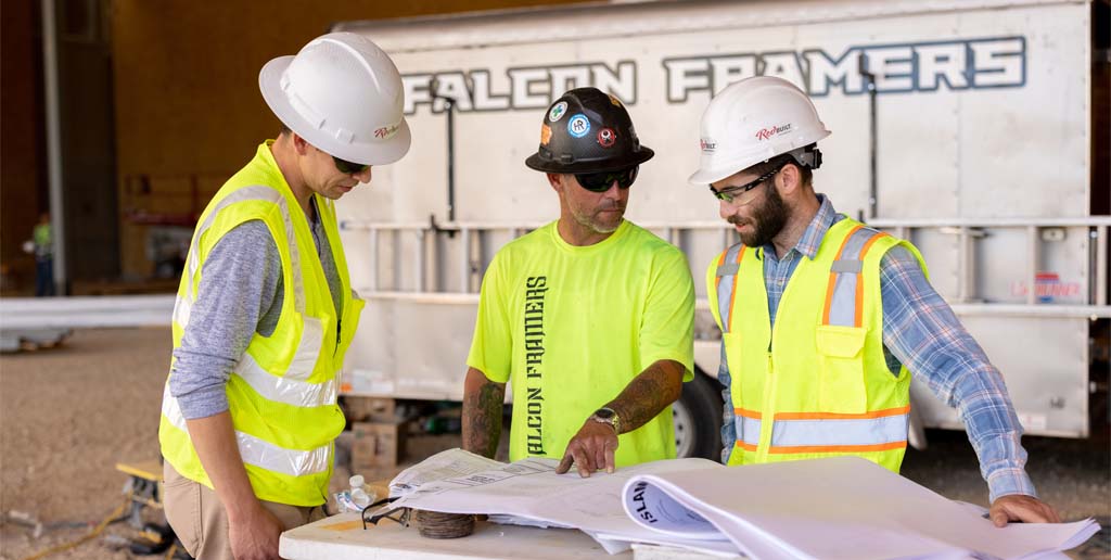 Workers at jobsite looking at plan set